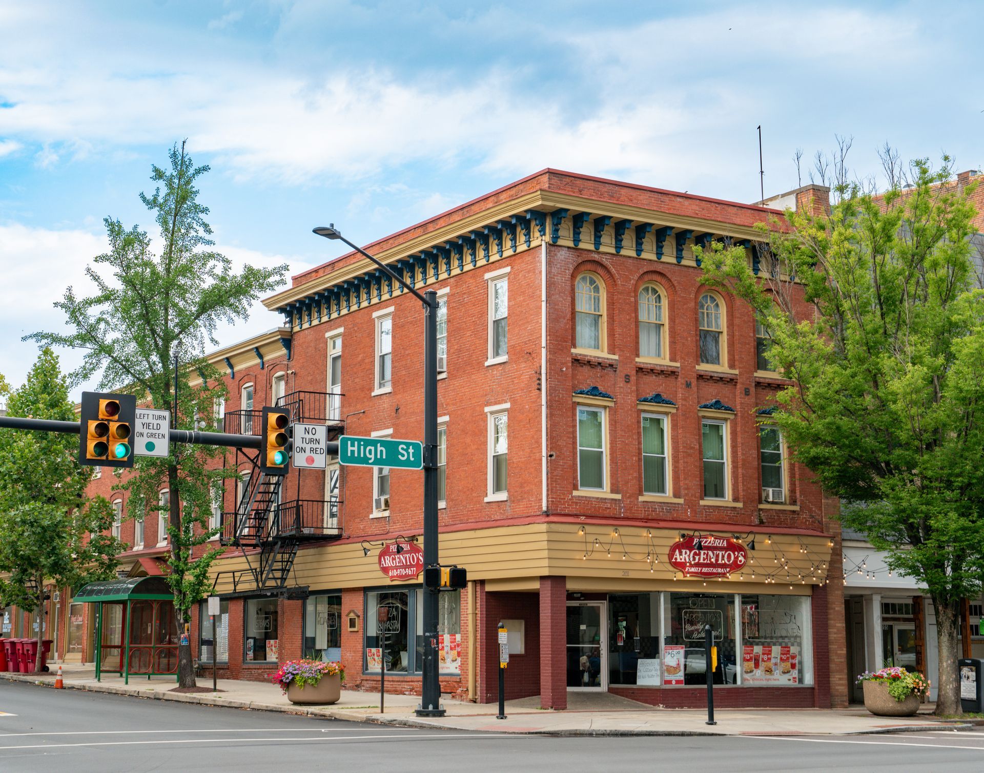 Photo of a 3 story red brick building, seen from across the street