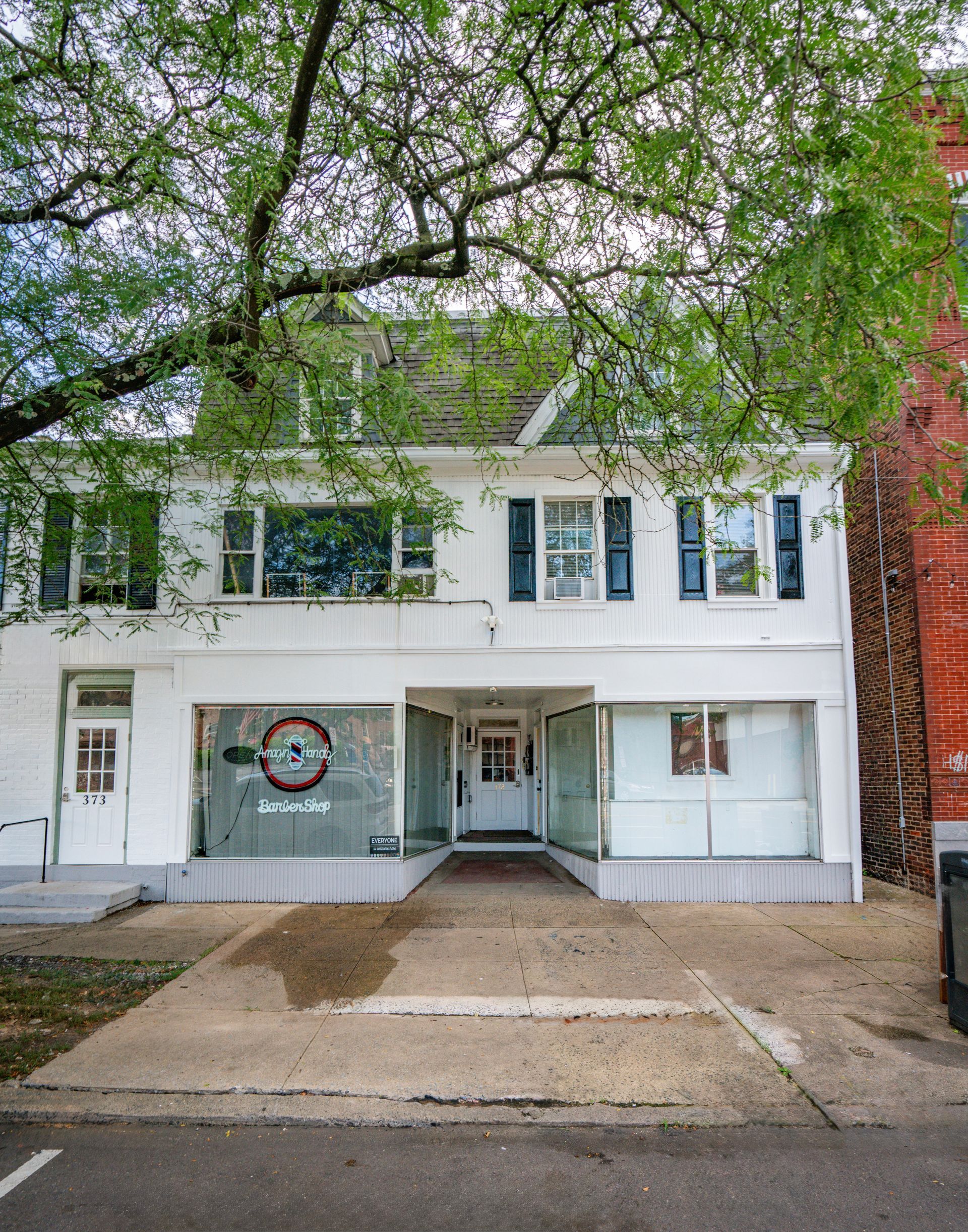 Photo of a building exterior showing a commercial space on the first floor and apartments on the second and third floors