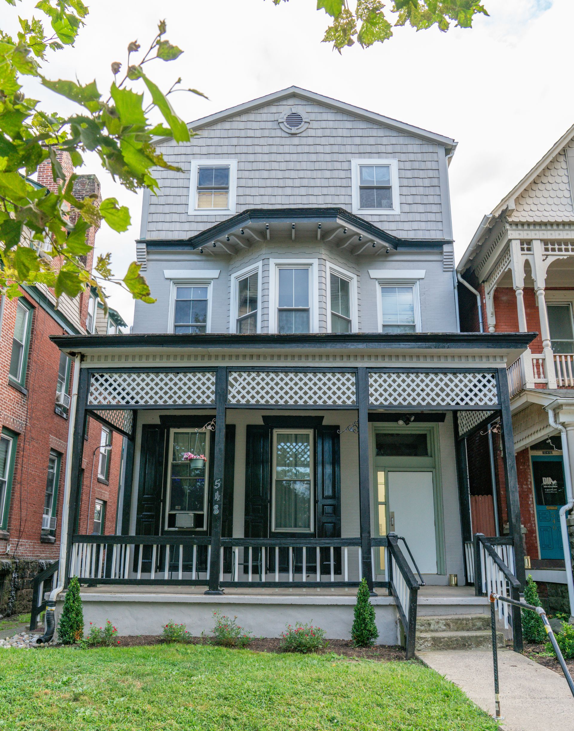 Photo of a 3-story building showing tree leaves at the top of the framing because of the low angle of the photo