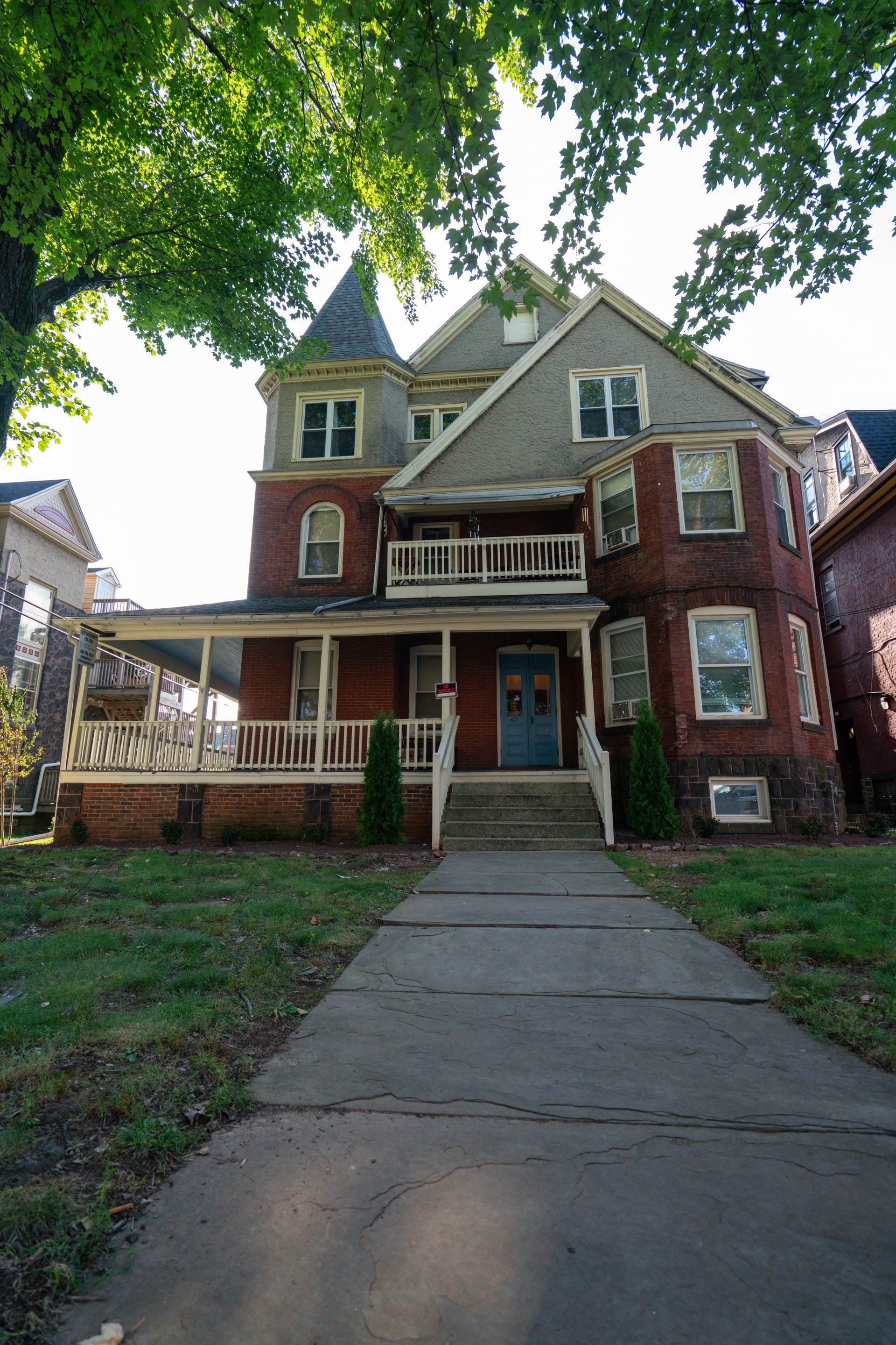 Photo of the front of a multi-story residential building, seen from the front walkway