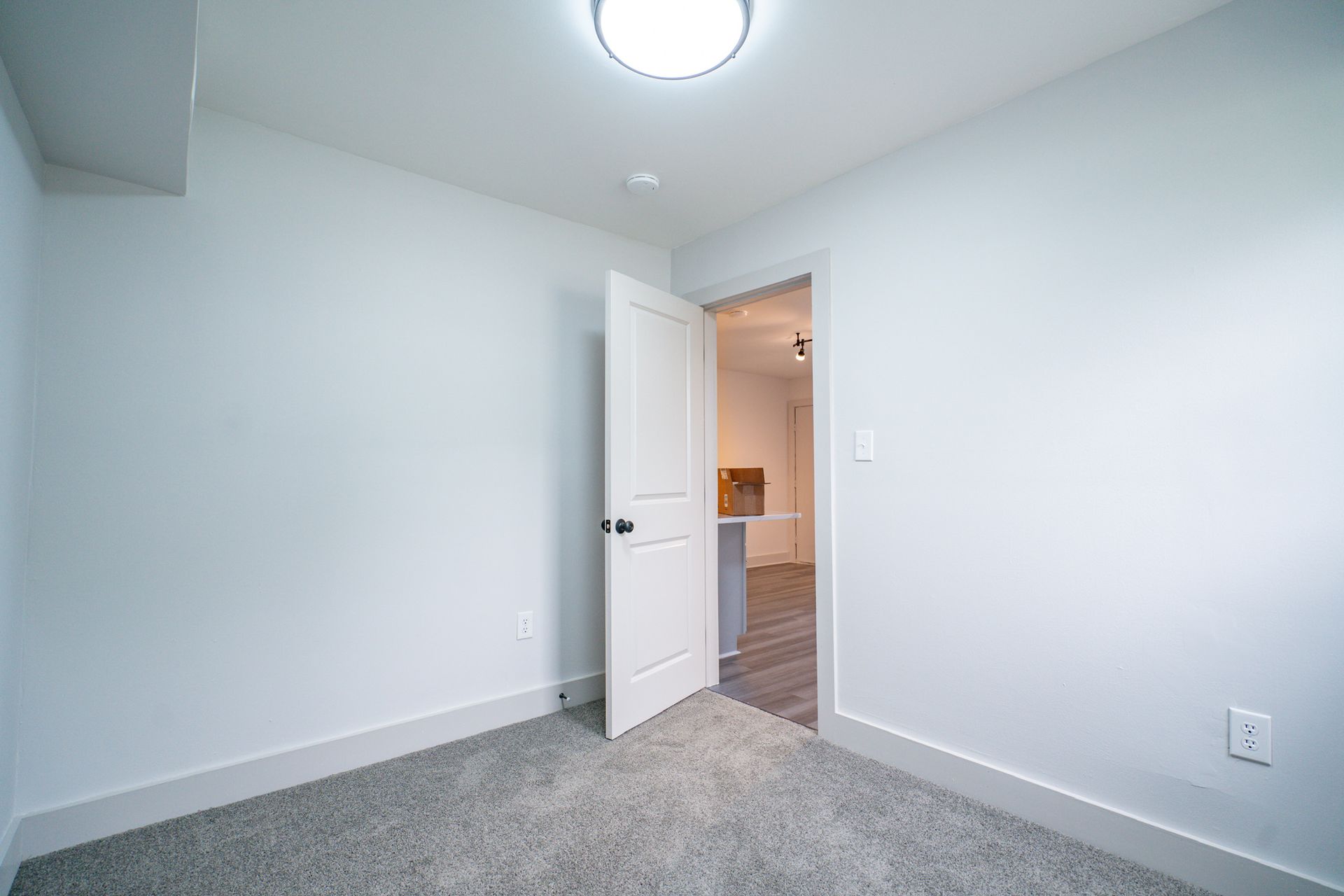 Photo of a room with carpeted flooring and an open door