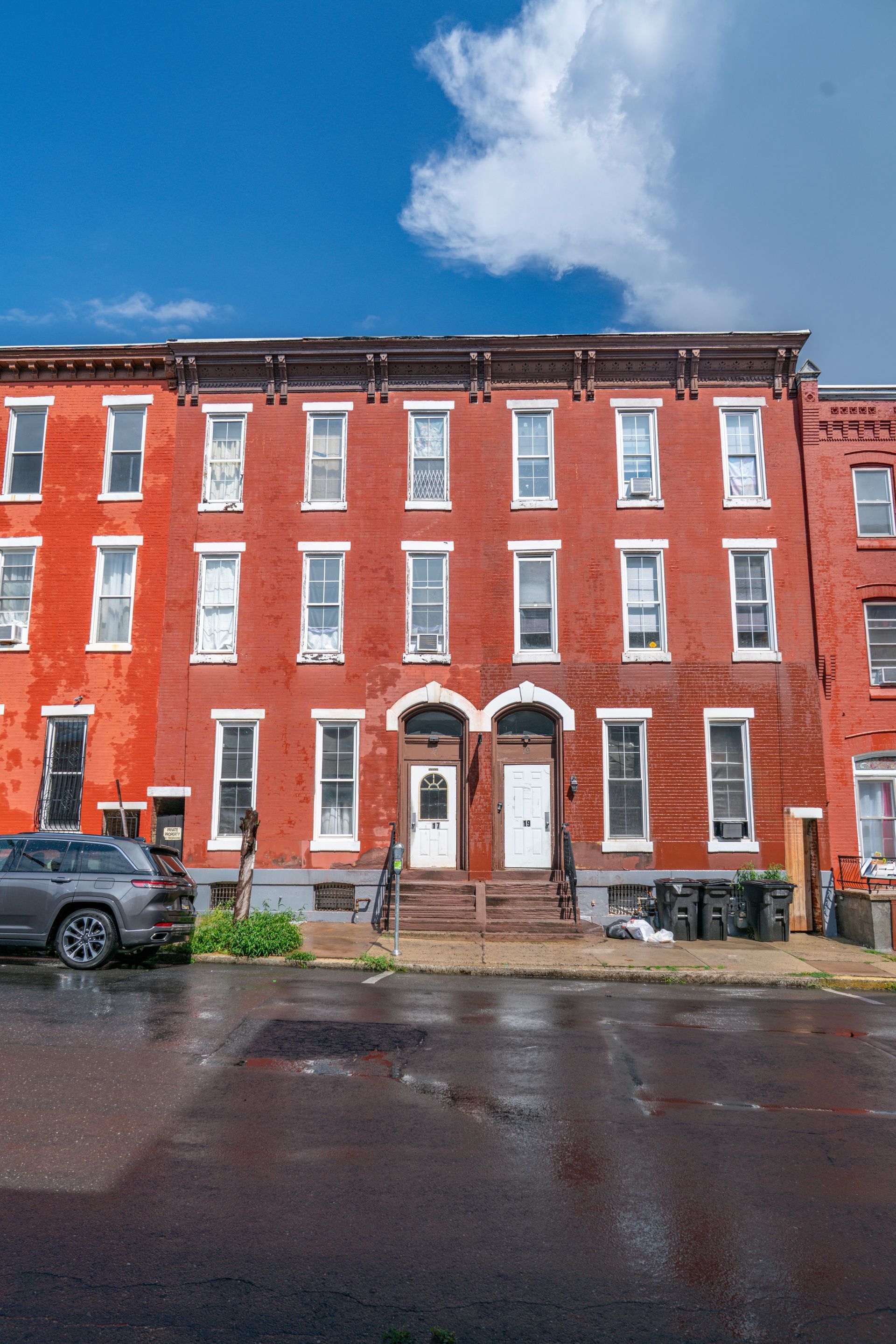Photo of the front of a large, red brick building, seen from across the street