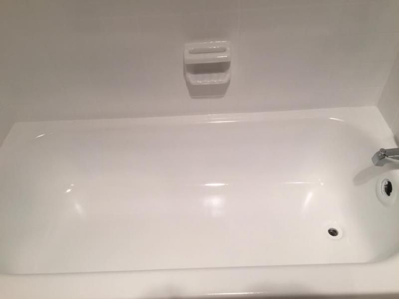 A clean white bathtub with a built-in soap dish and faucet hardware on the right side.