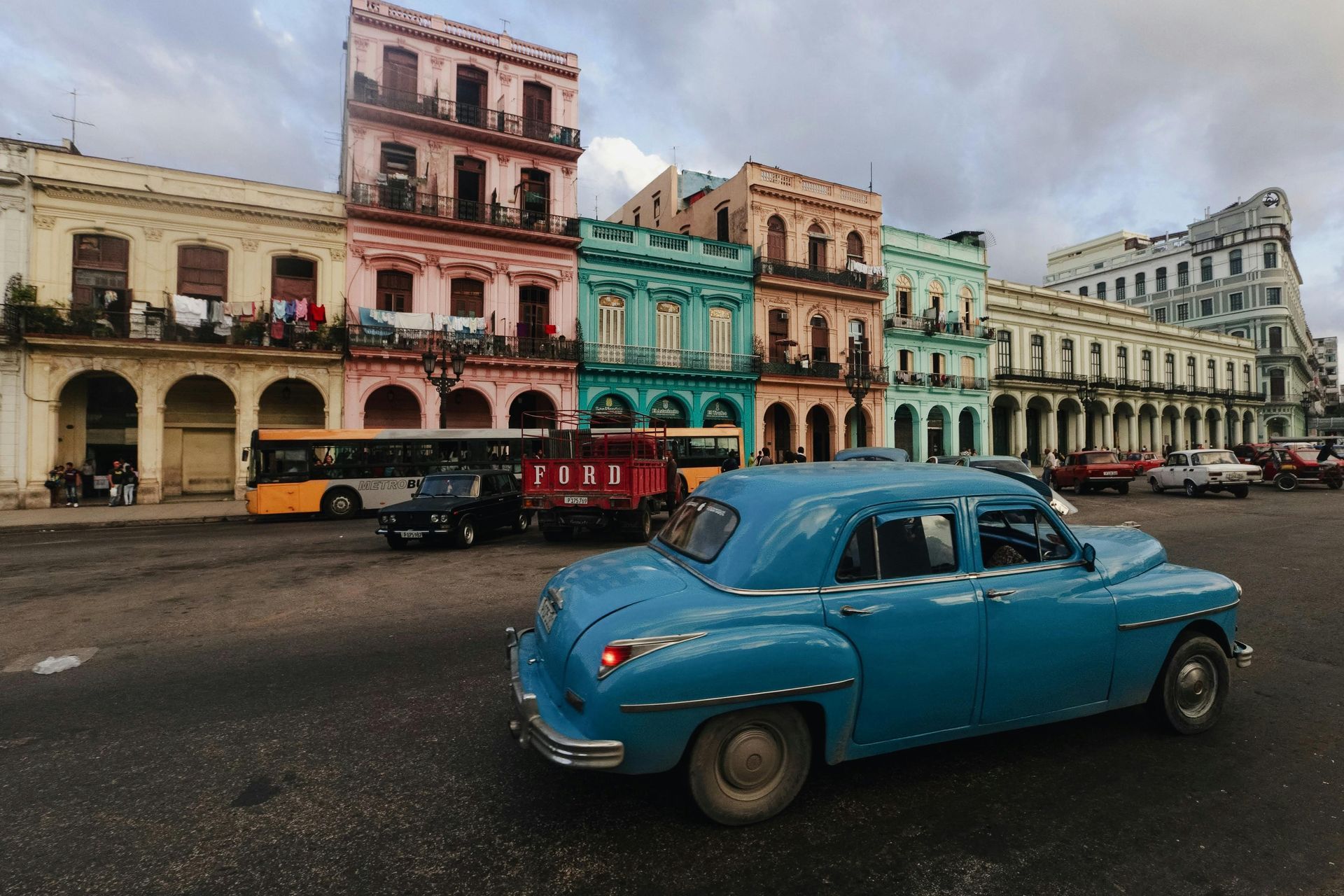 Auto d'epoca blu in via Havana; sullo sfondo edifici colorati.