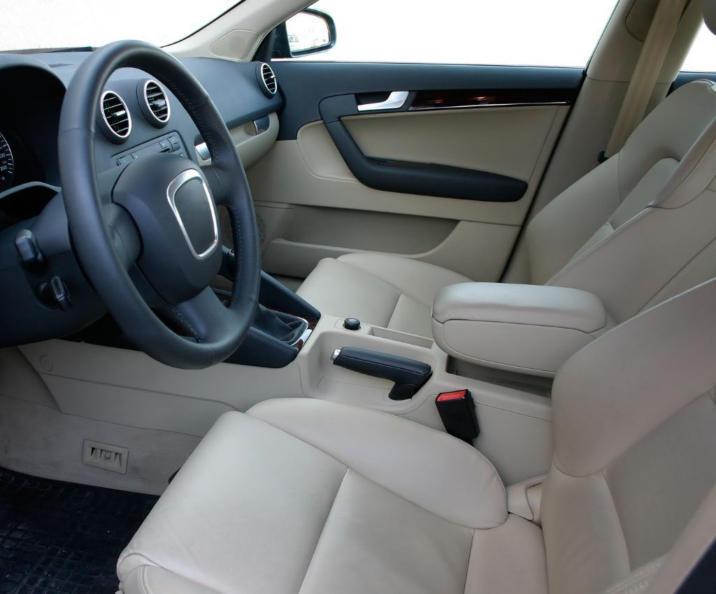 Beige leather interior of an Audi, including the steering wheel, seats, and dashboard.