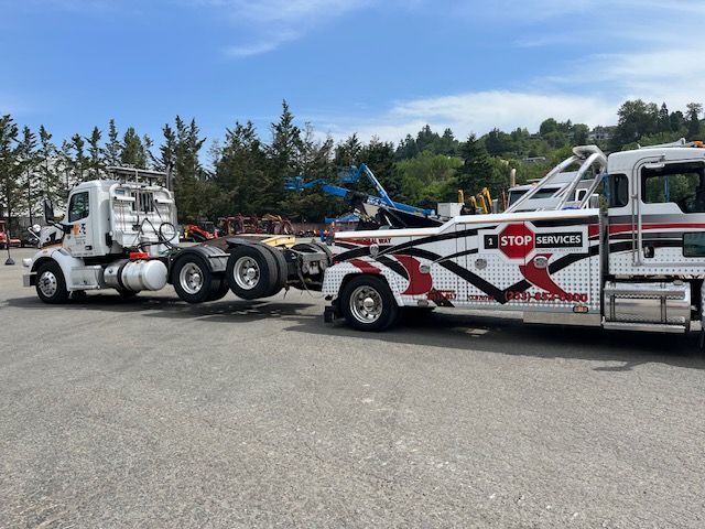 Two tow trucks are parked next to each other in a parking lot.