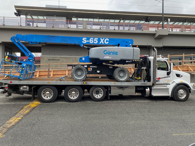 A tow truck with a genie lift on the back of it