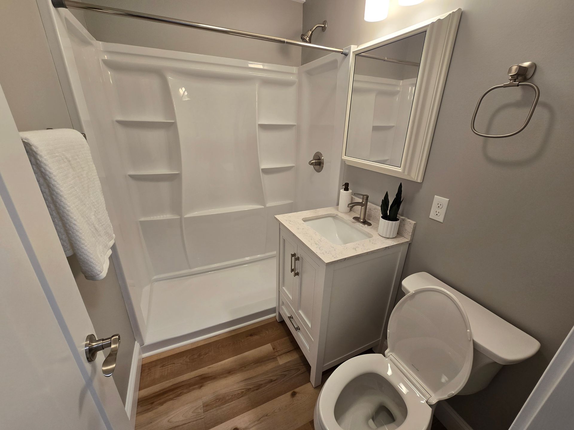 Interior photo of 371 Elm St bathroom with a toilet , sink , shower and mirror.