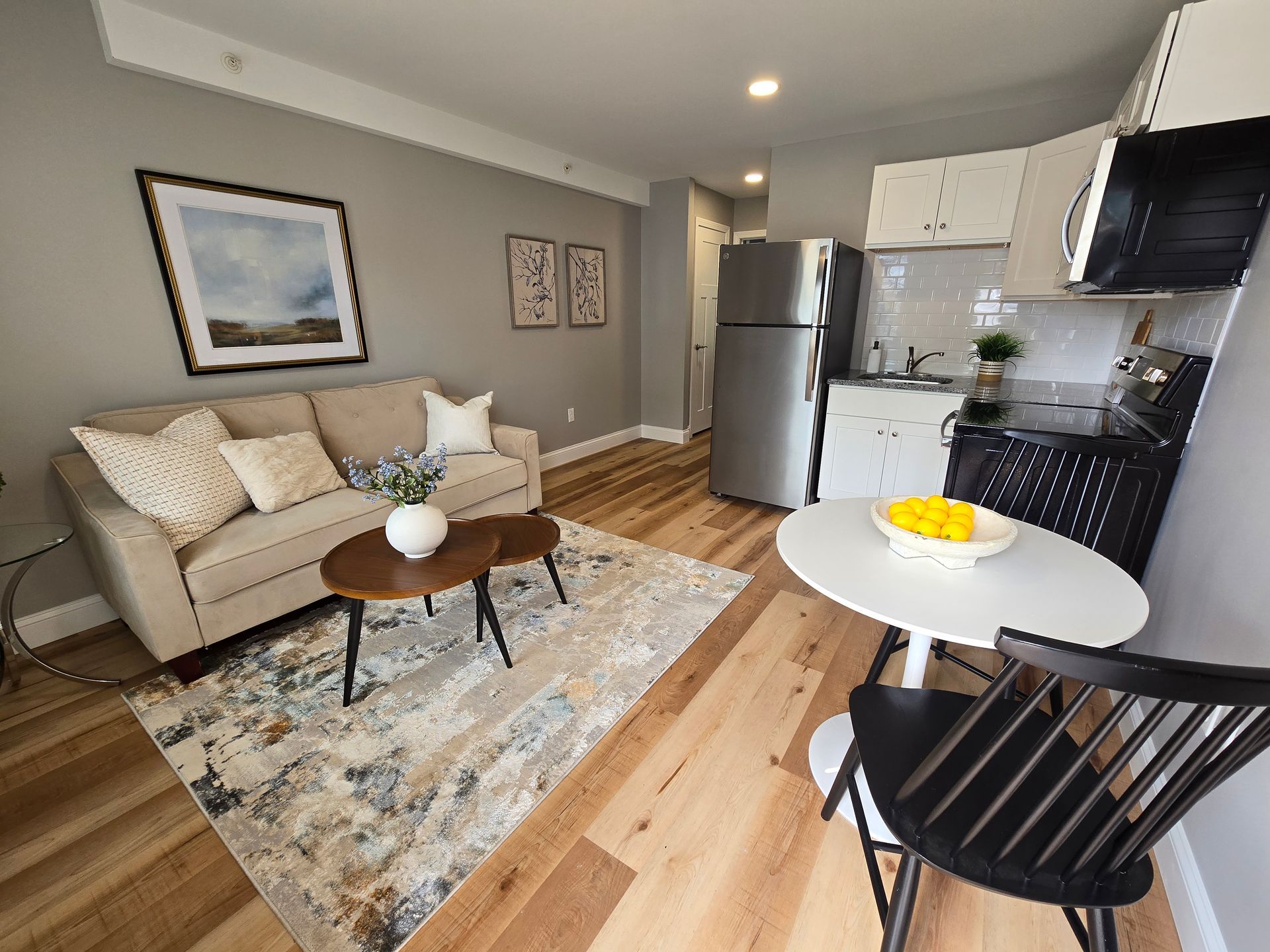 Interior photo of 371 Elm St living room with a couch , table , chairs and a refrigerator.