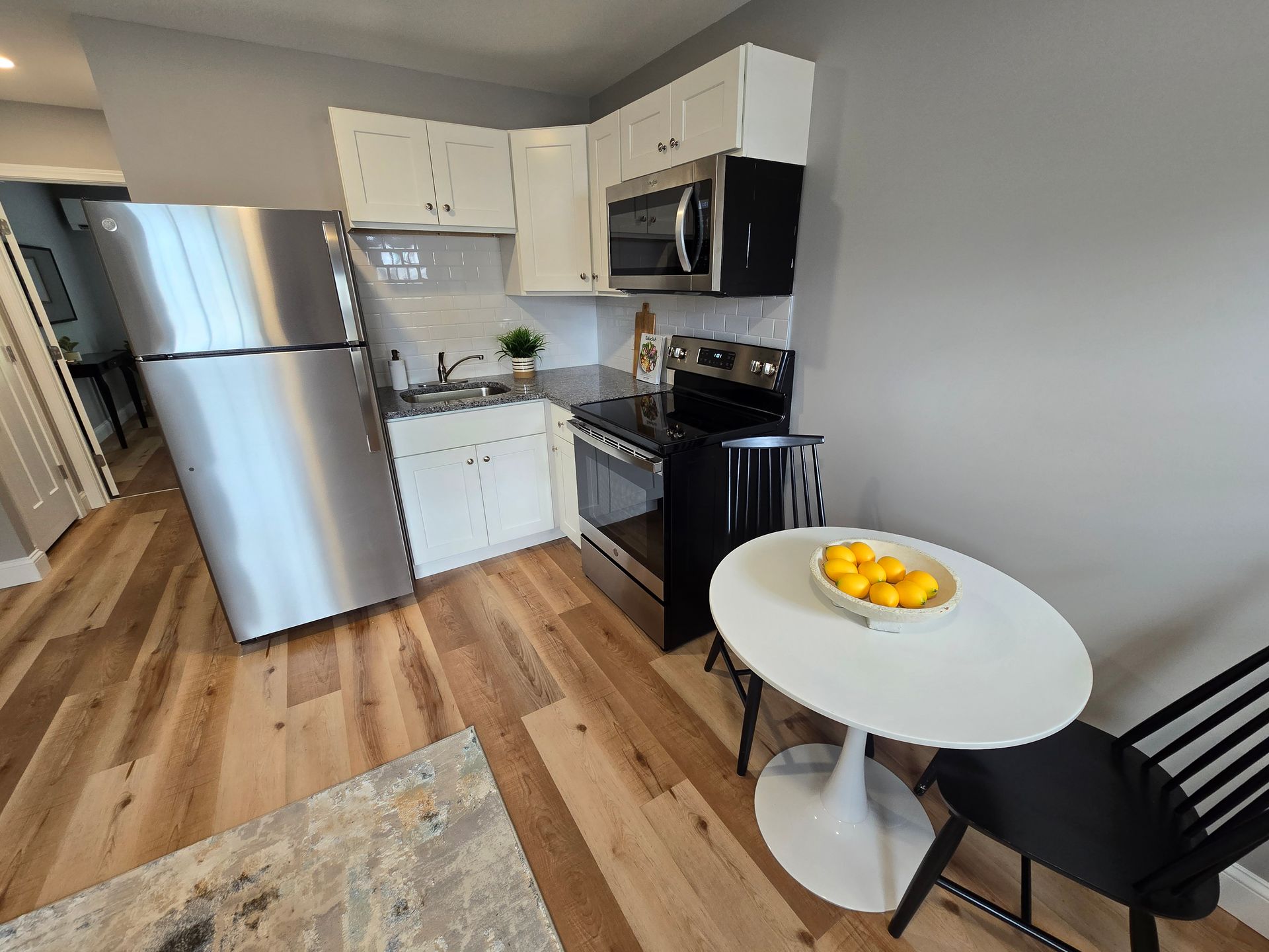 Interior photo of 371 Elm St kitchen with a stainless steel refrigerator , stove , microwave , table and chairs.