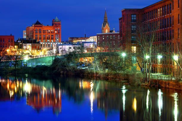 A city at night with a river in the foreground and buildings in the background.