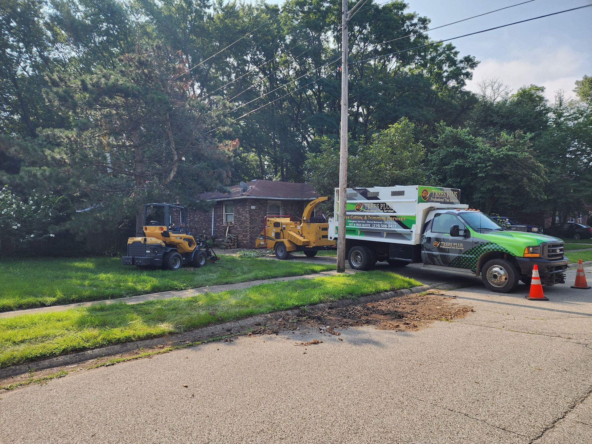 A truck is parked on the side of the road next to a lawn mower.