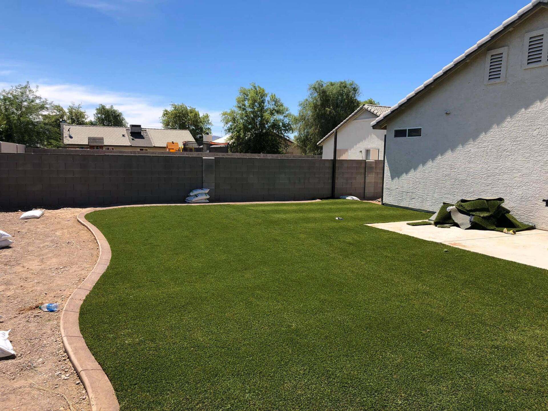 A backyard with a lot of grass and a house in the background