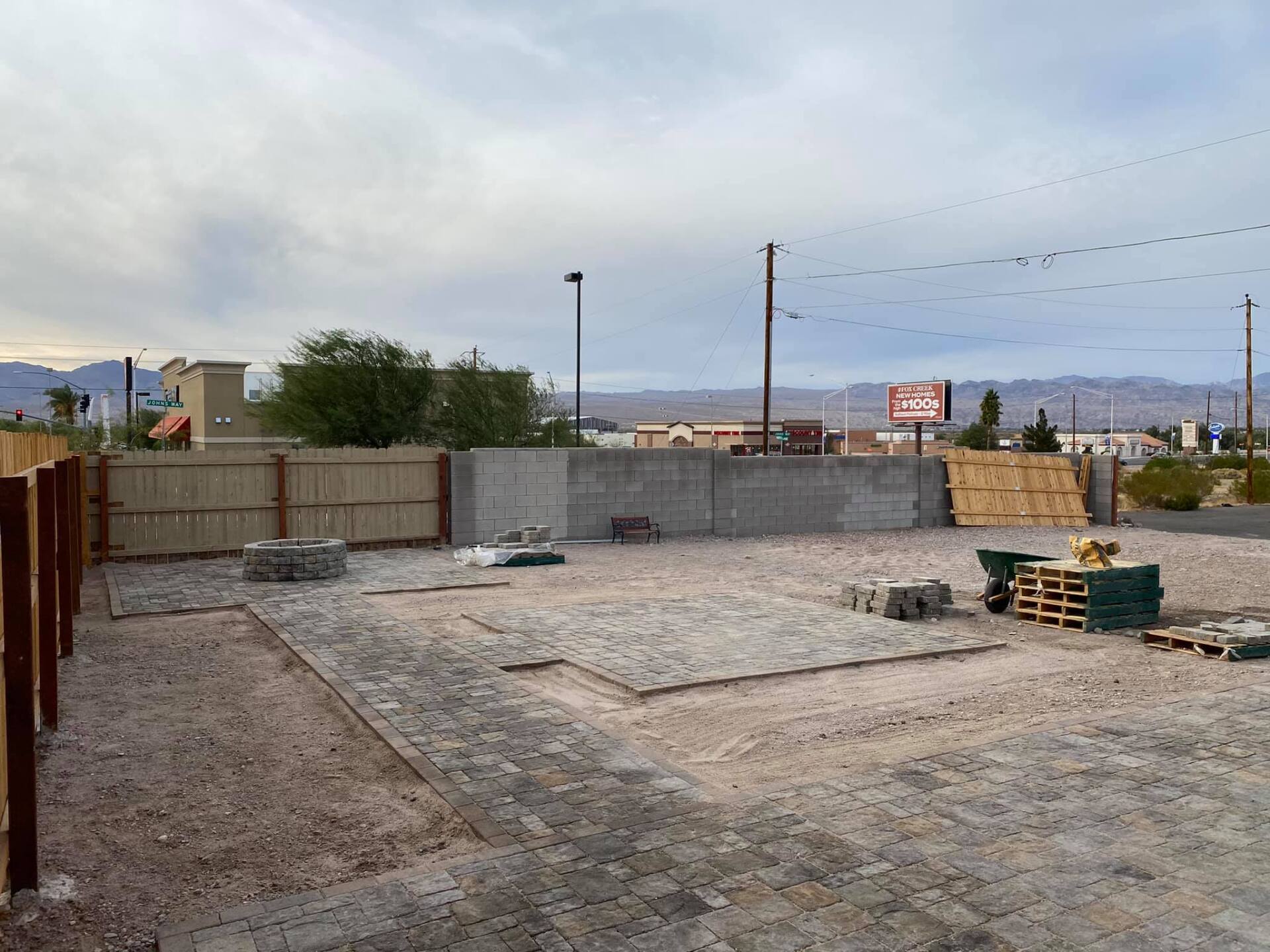 A construction site with a fence and a lot of dirt.