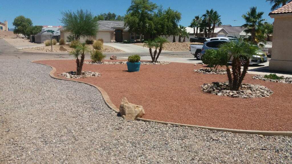 A gravel driveway with a few trees in the middle