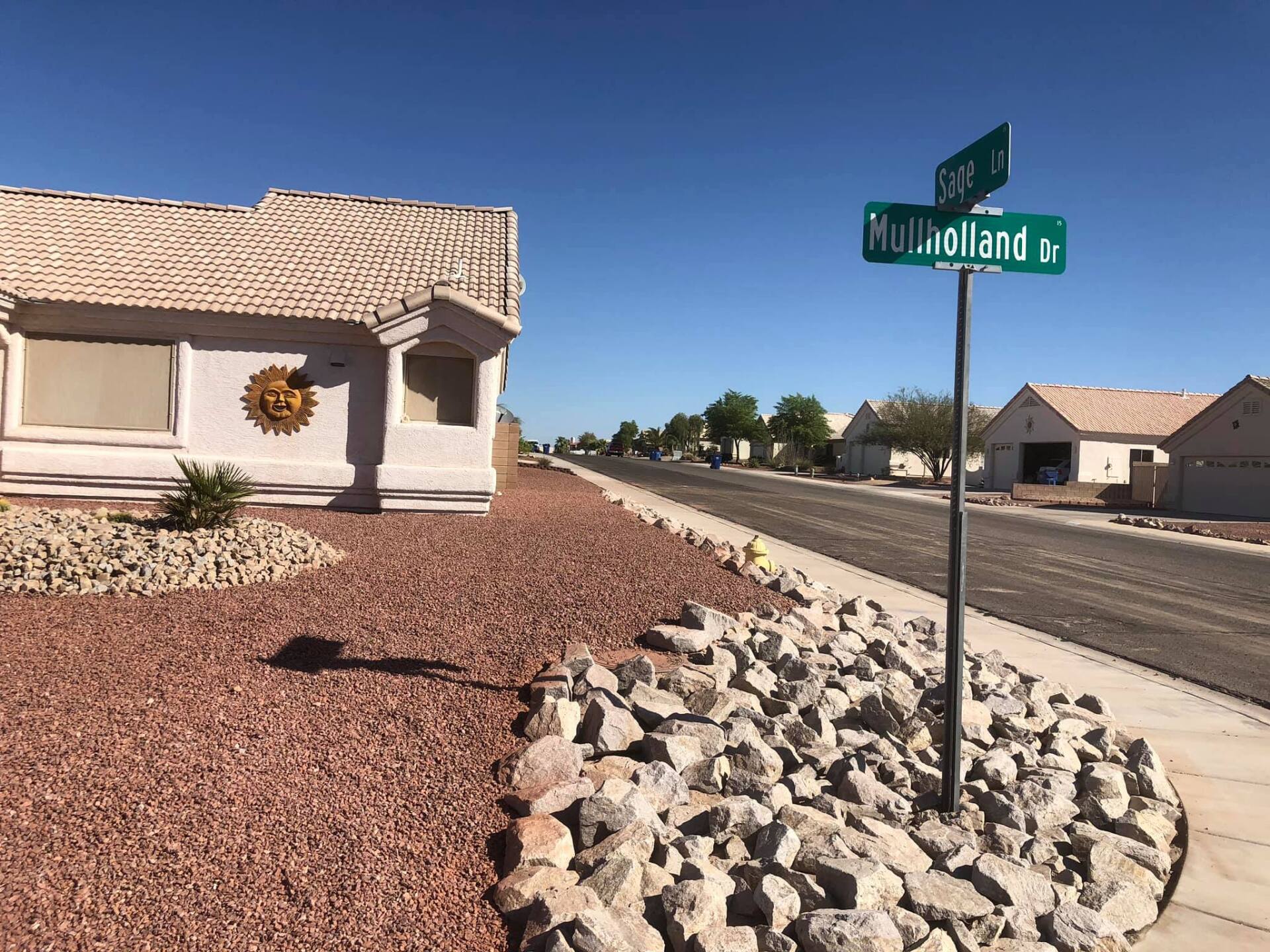 A street sign for miller boulevard is in front of a house
