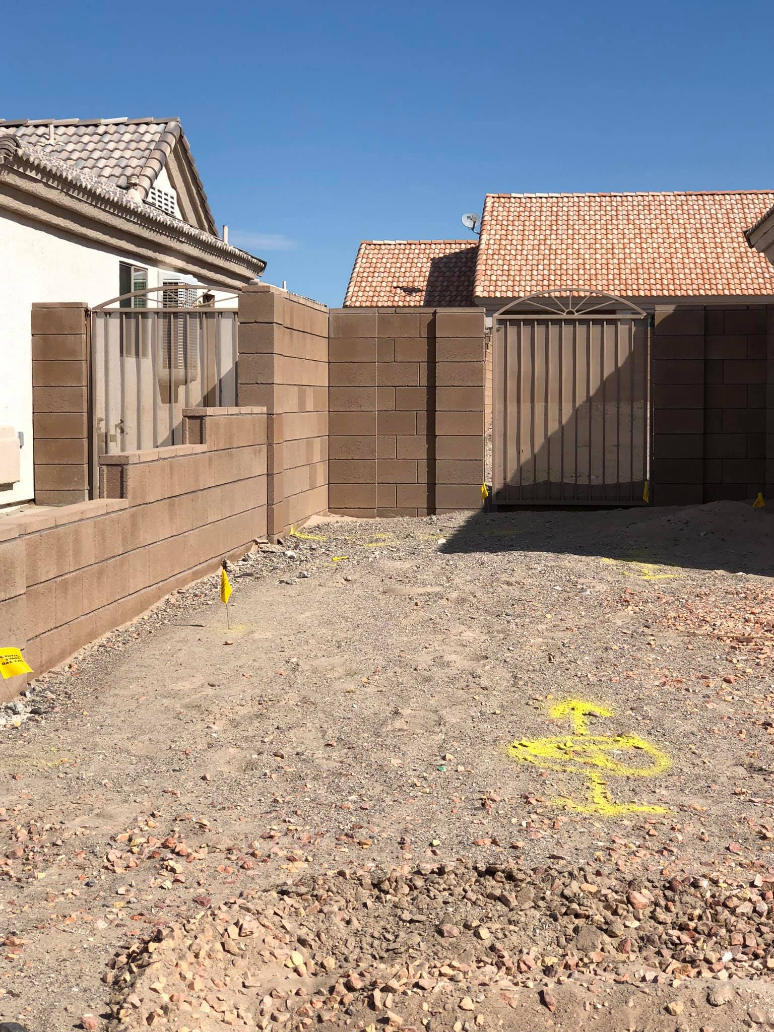 A brick wall is being built in front of a house.