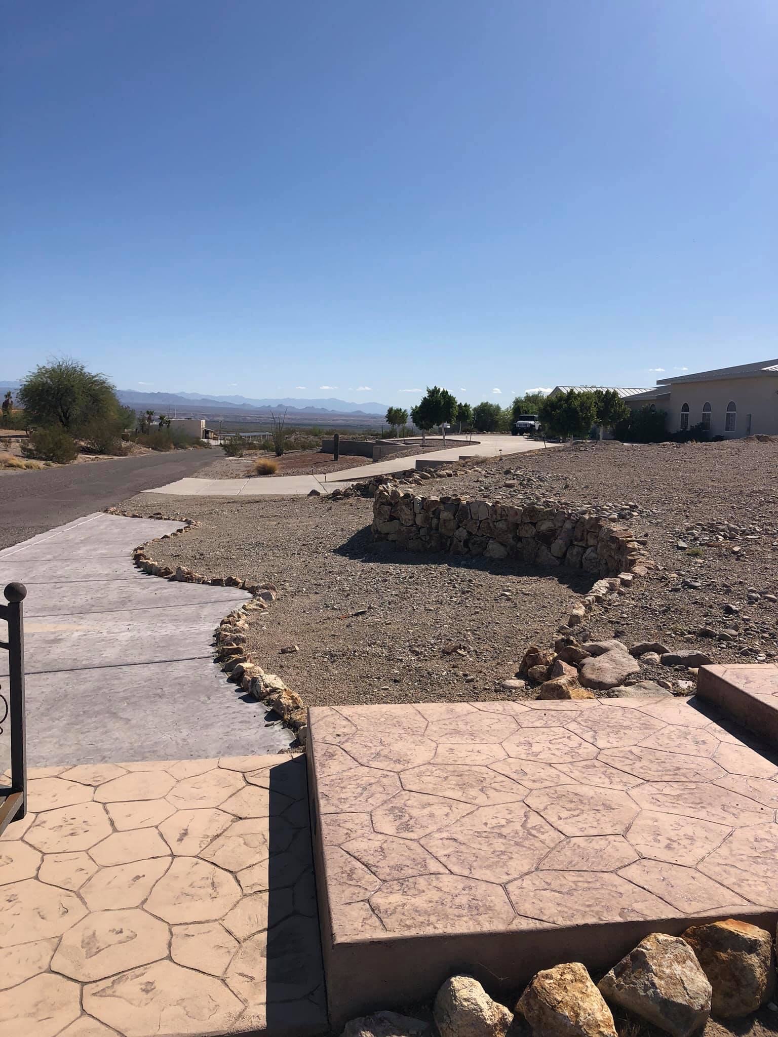 A rocky area with a building in the background and a blue sky