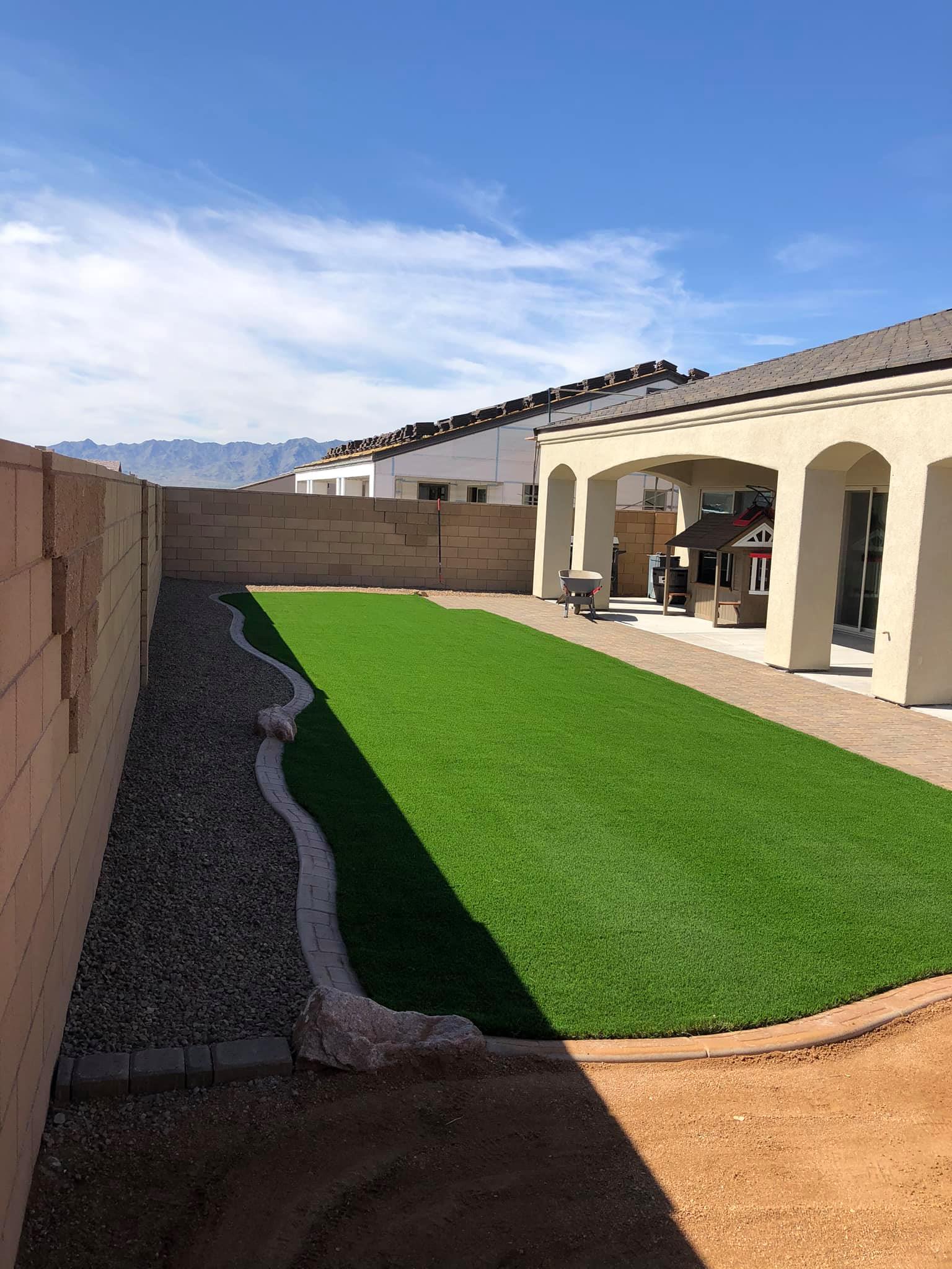 There is a large lawn in the backyard of a house.