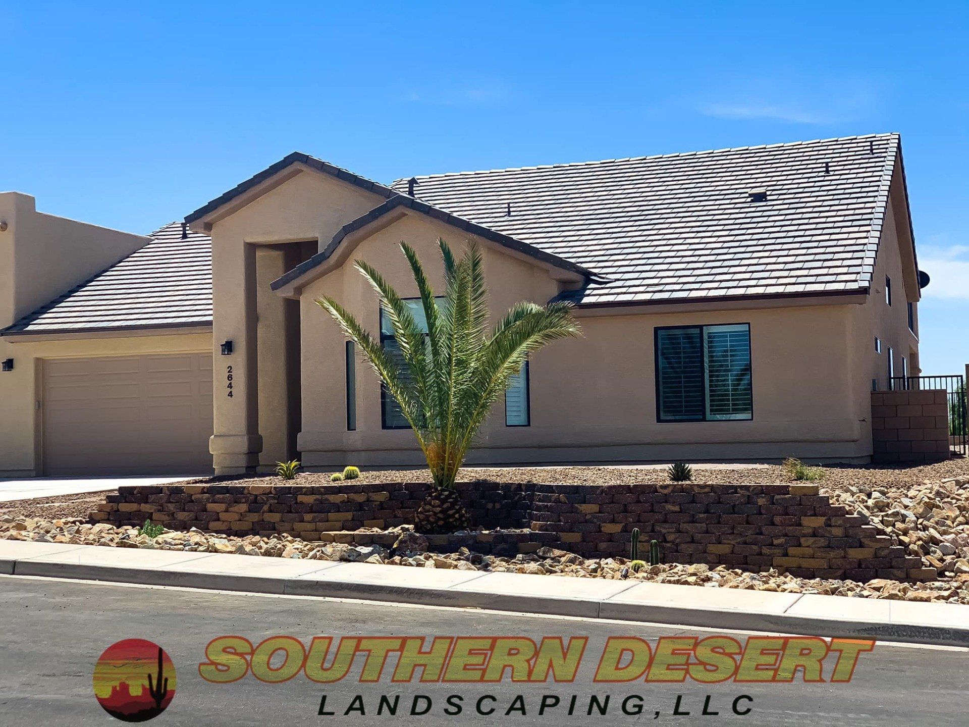 A house with a palm tree in front of it and a sign that says southern desert landscaping llc