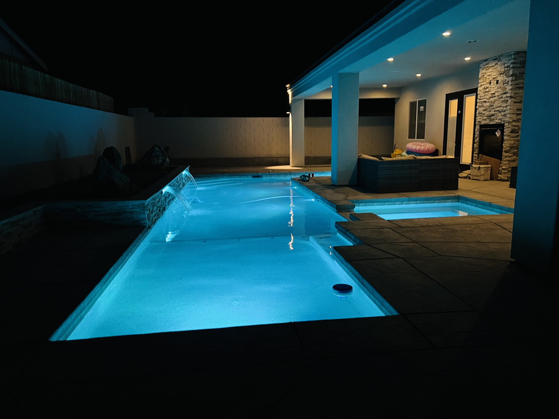 A large swimming pool is lit up at night