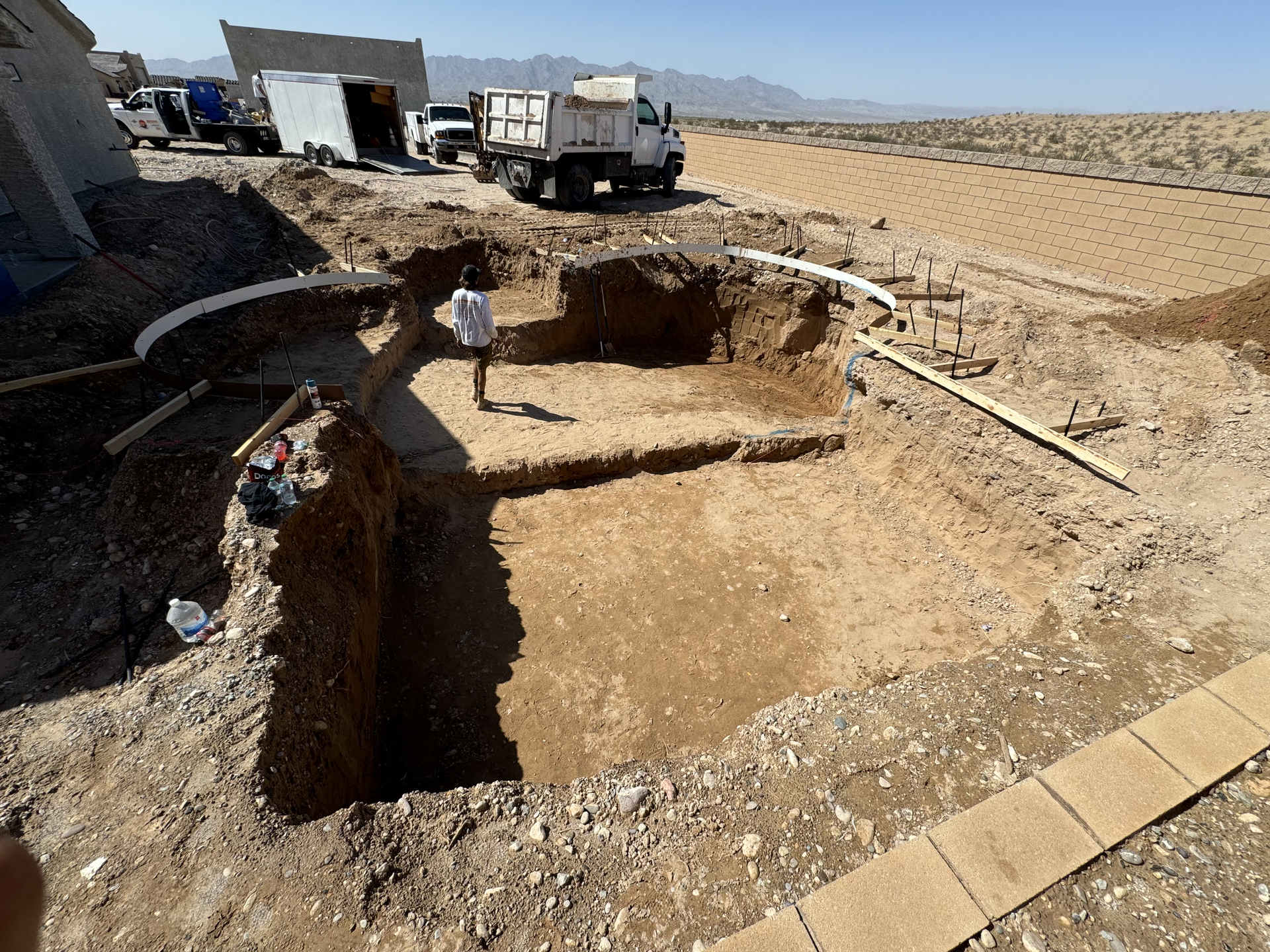 A large hole in the ground with a truck in the background