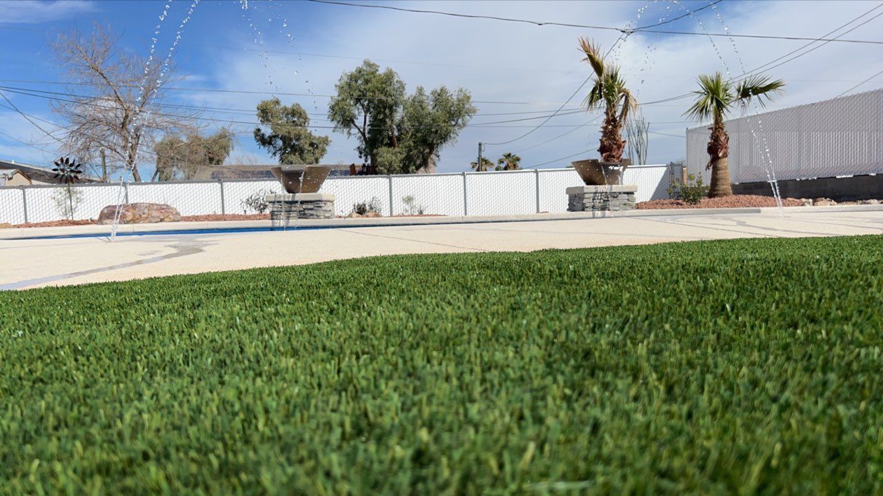 A sprinkler is spraying water on a lush green lawn.