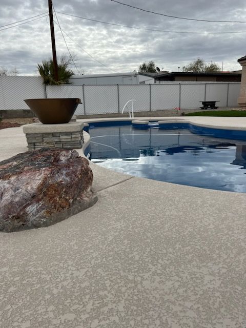 A large rock sits on the edge of a swimming pool.