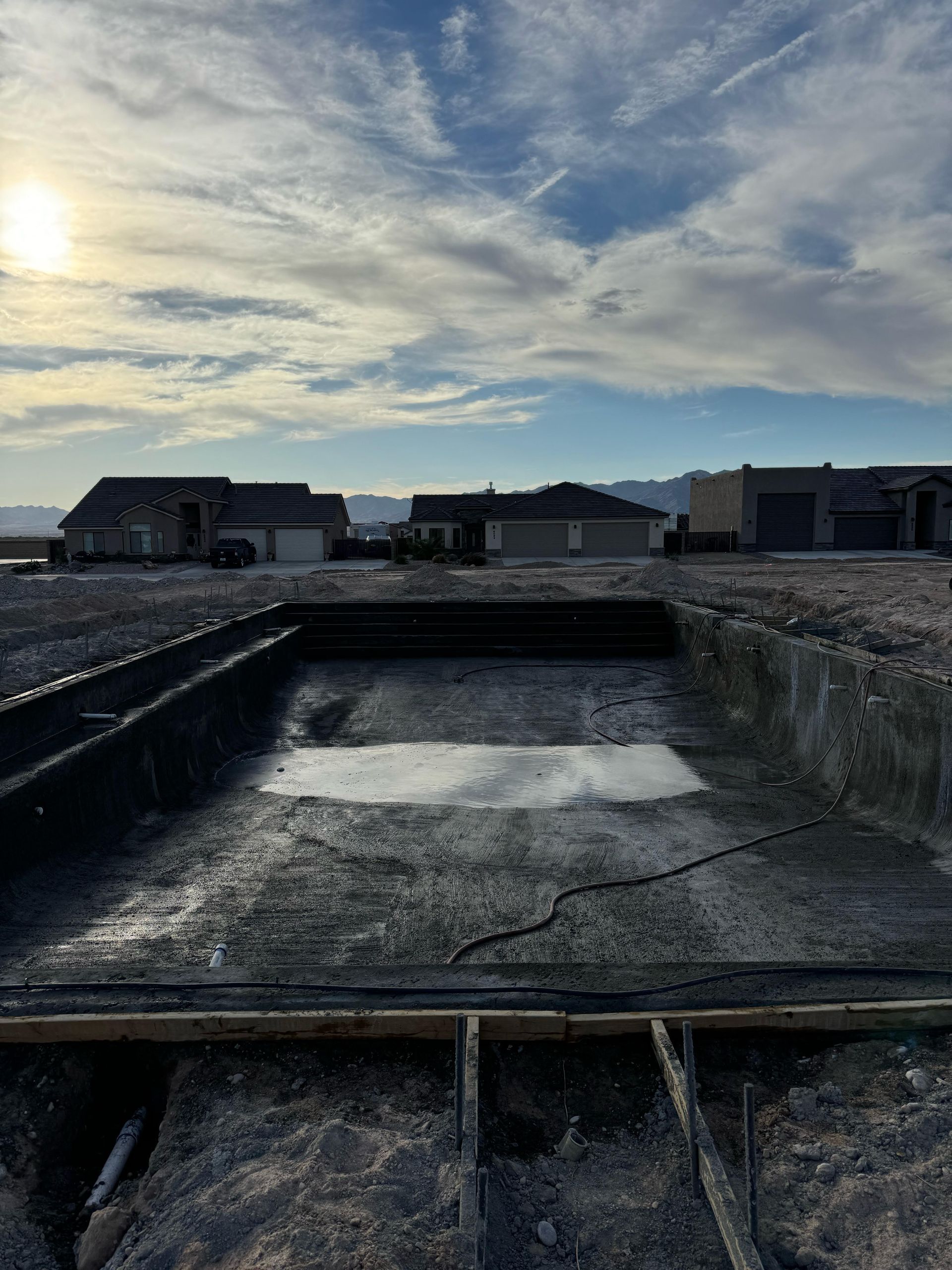 A large hole in the ground is being filled with concrete.