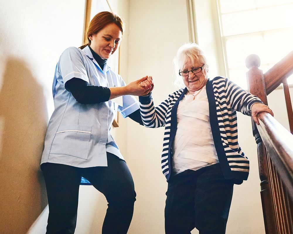 Caregiver Helping Senior Woman Walking Down the Stairs — Semmes, AL — My Happy Seniors