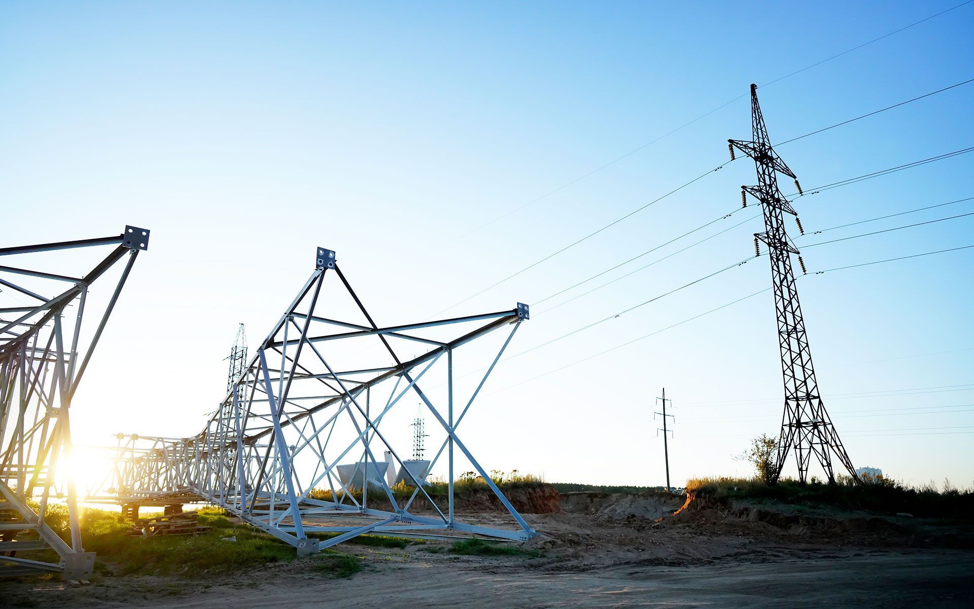 Power lines and towers against a bright sky.