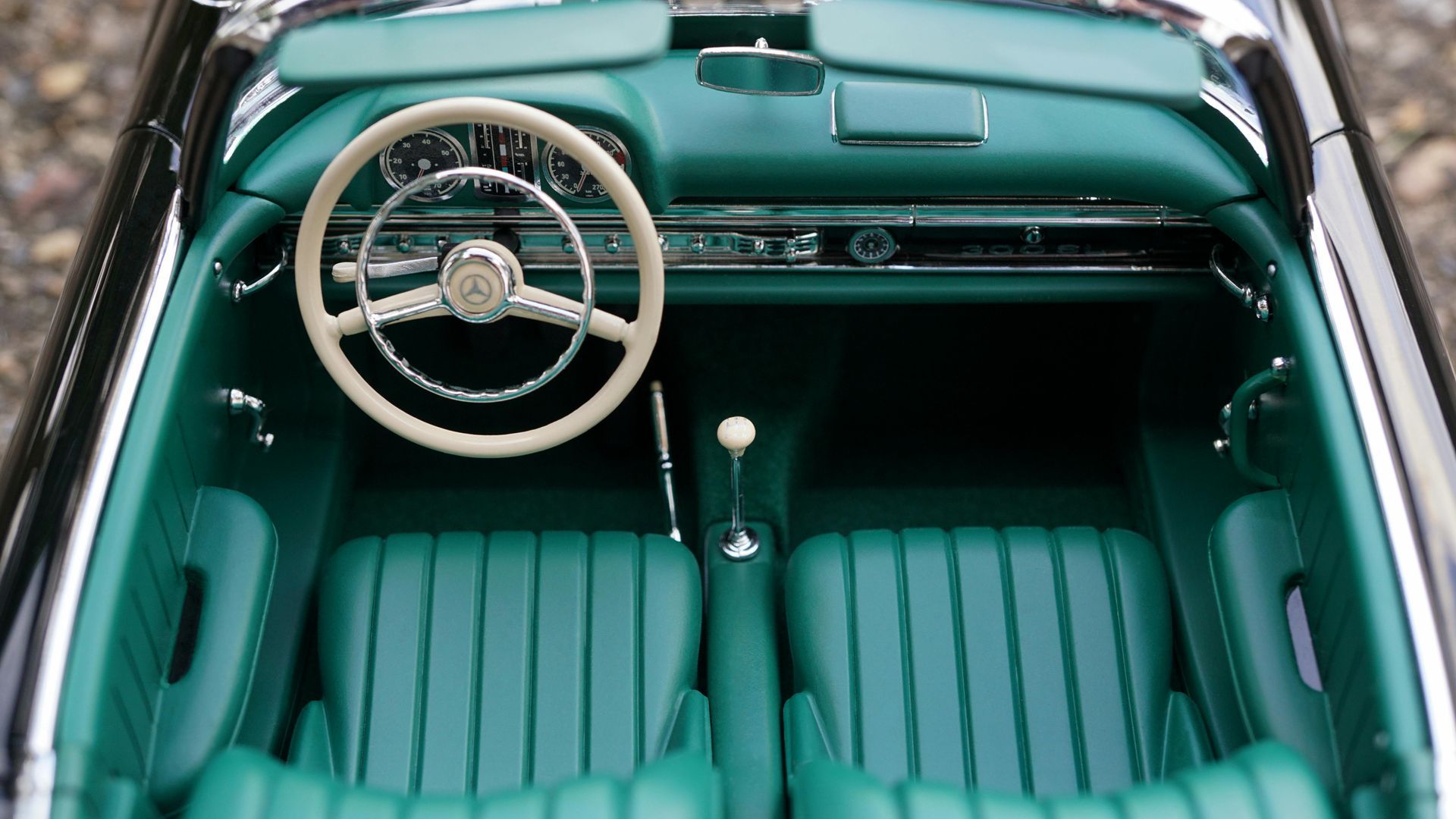 The interior of a black car with green seats and a steering wheel.