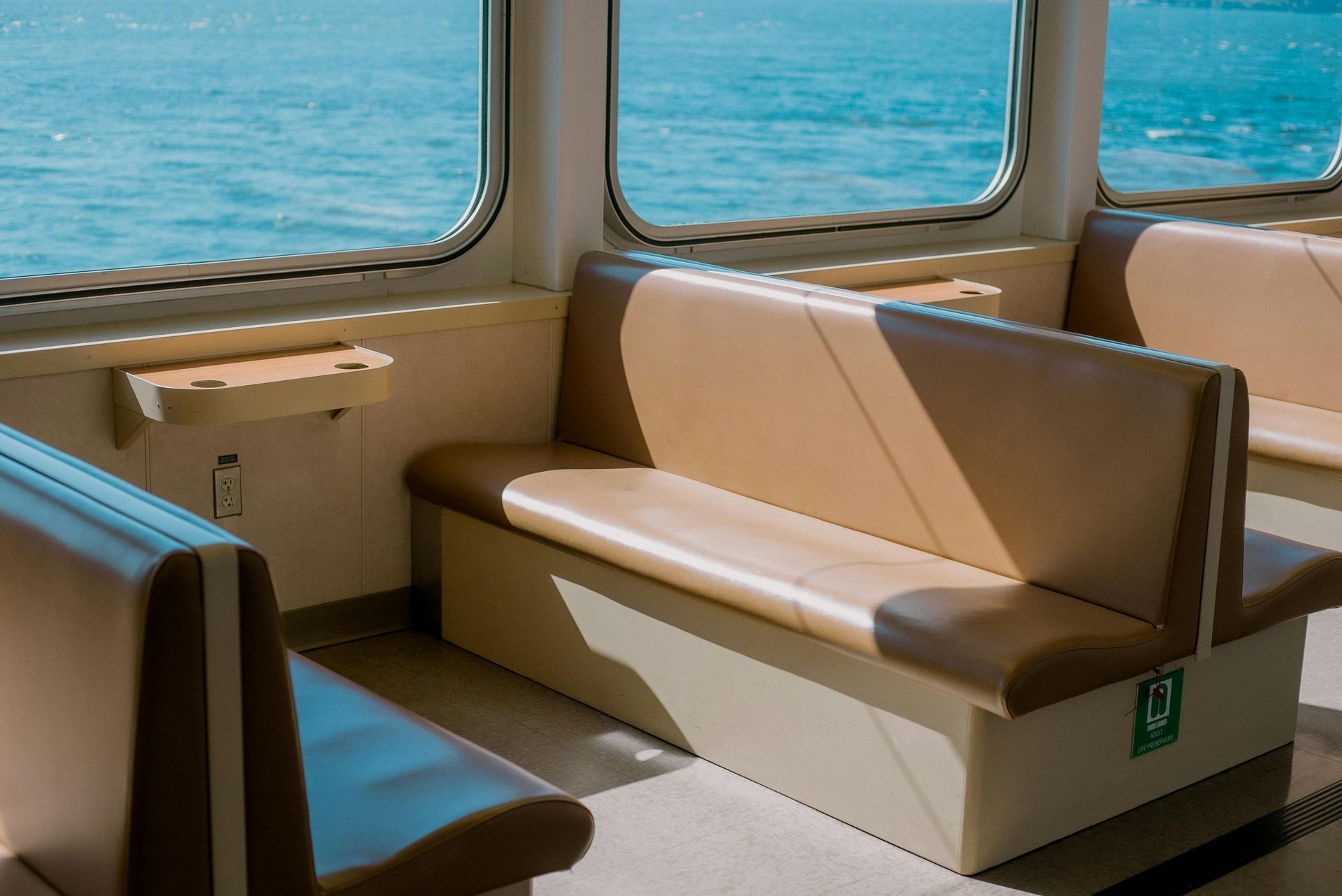 A boat with a lot of seats and a window overlooking the water