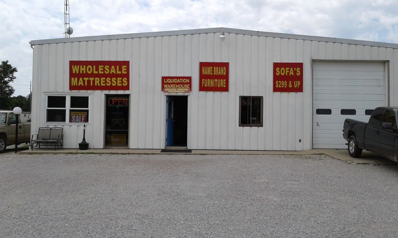 A truck is parked in front of a wholesale mattress store