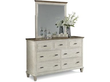 A white dresser with drawers and a mirror on top of it.