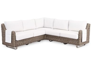 A wicker sectional couch with white cushions on a white background.