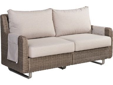 A wicker couch with white cushions on a white background