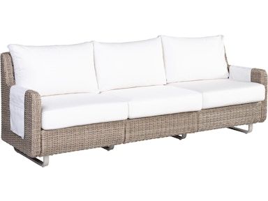 A wicker couch with white cushions on a white background
