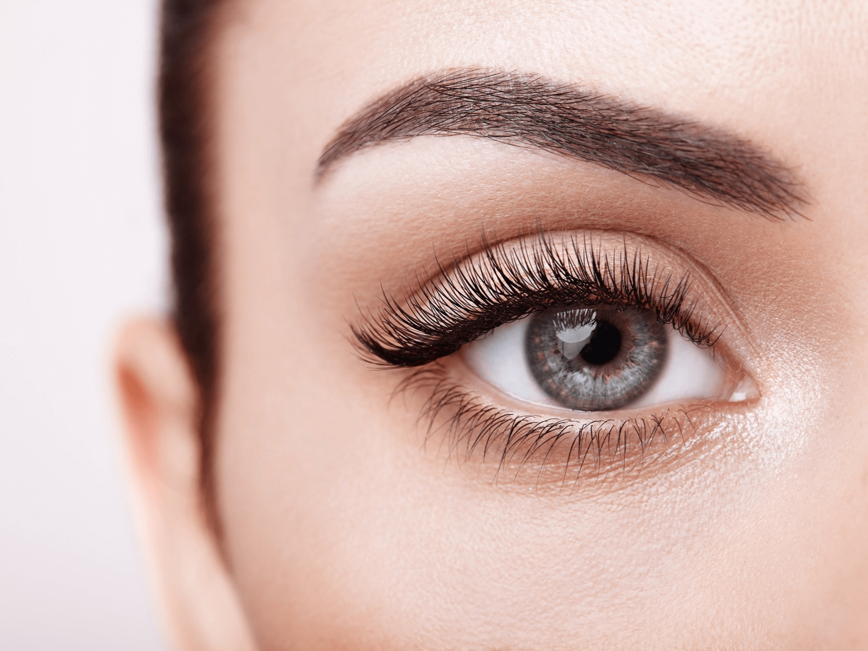 A close up of a woman 's eye with long eyelashes and eyeliner.