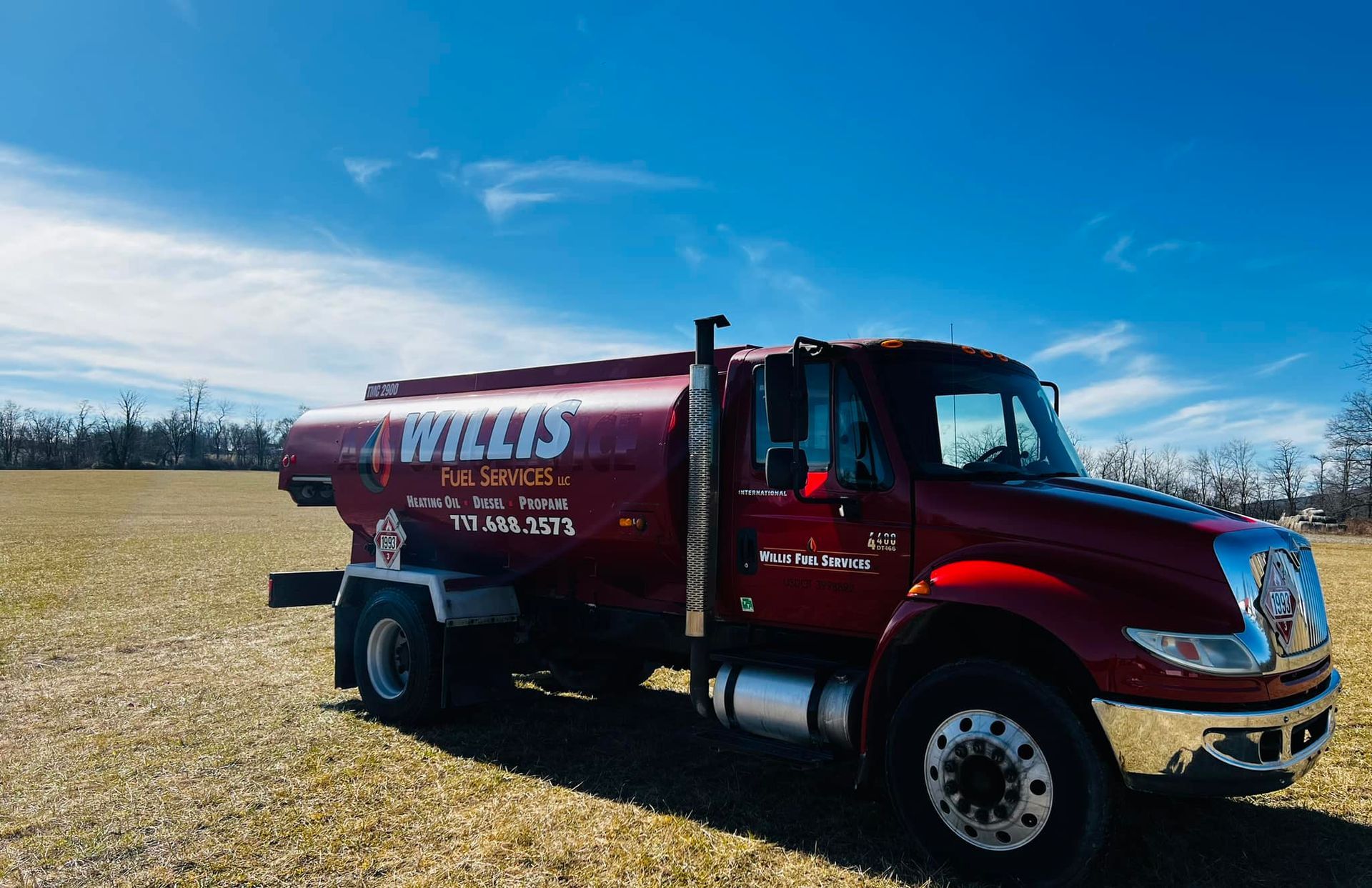 A red truck is parked in a grassy field – York Springs, PA – Willis Fuel Services LLC