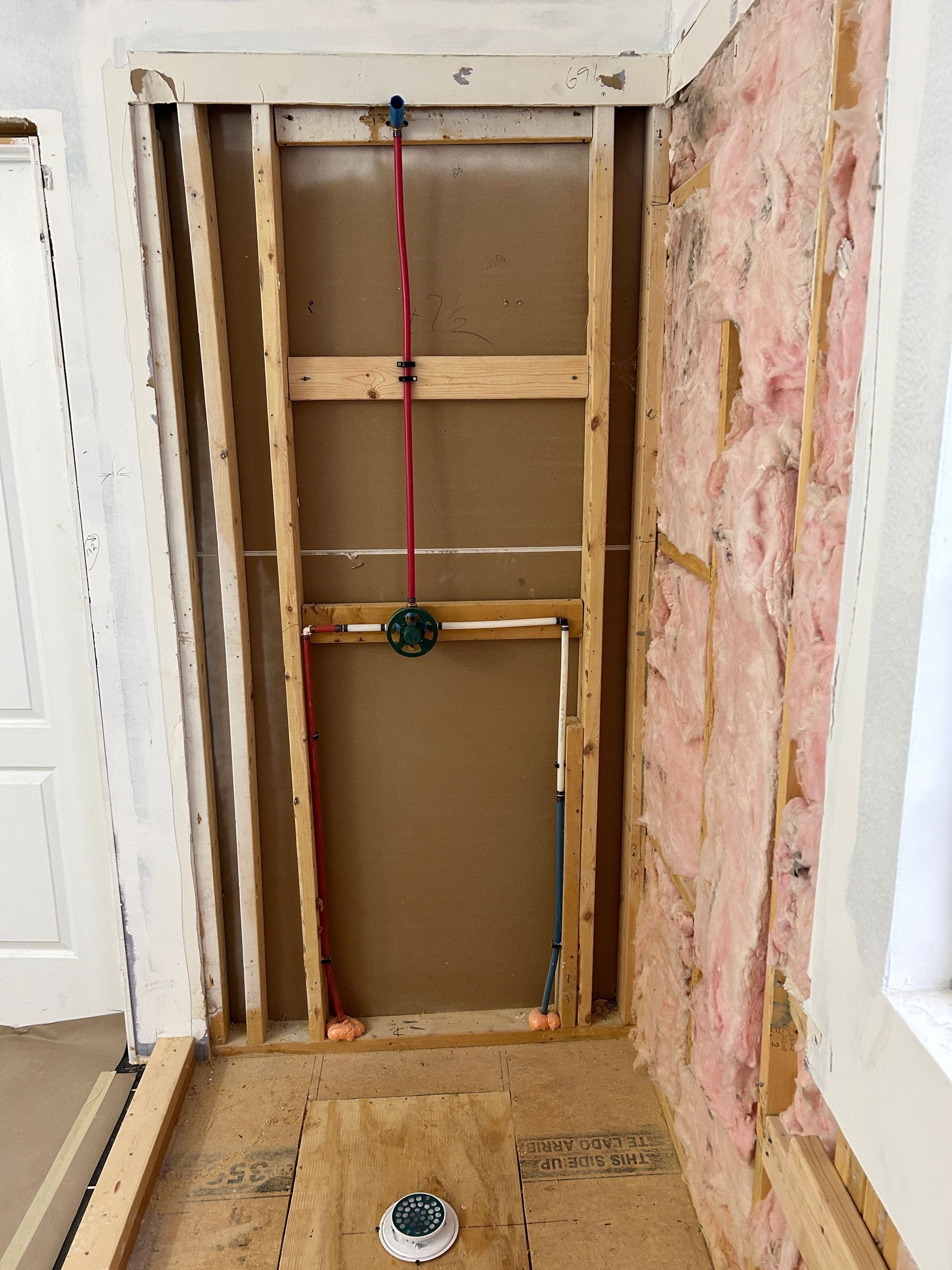 A room with a wooden frame and insulation on the wall.