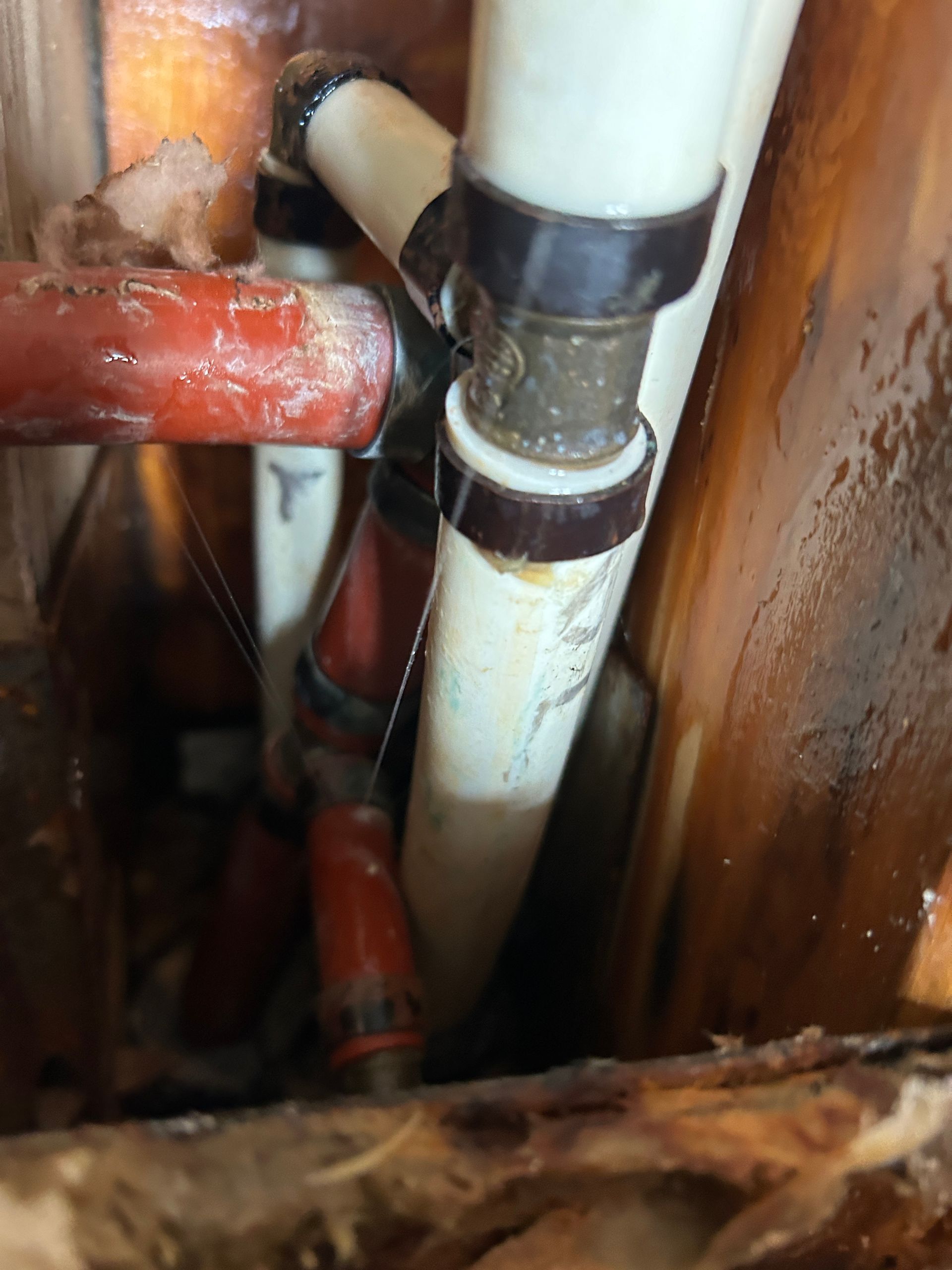 A close up of a pipe in a wooden wall.