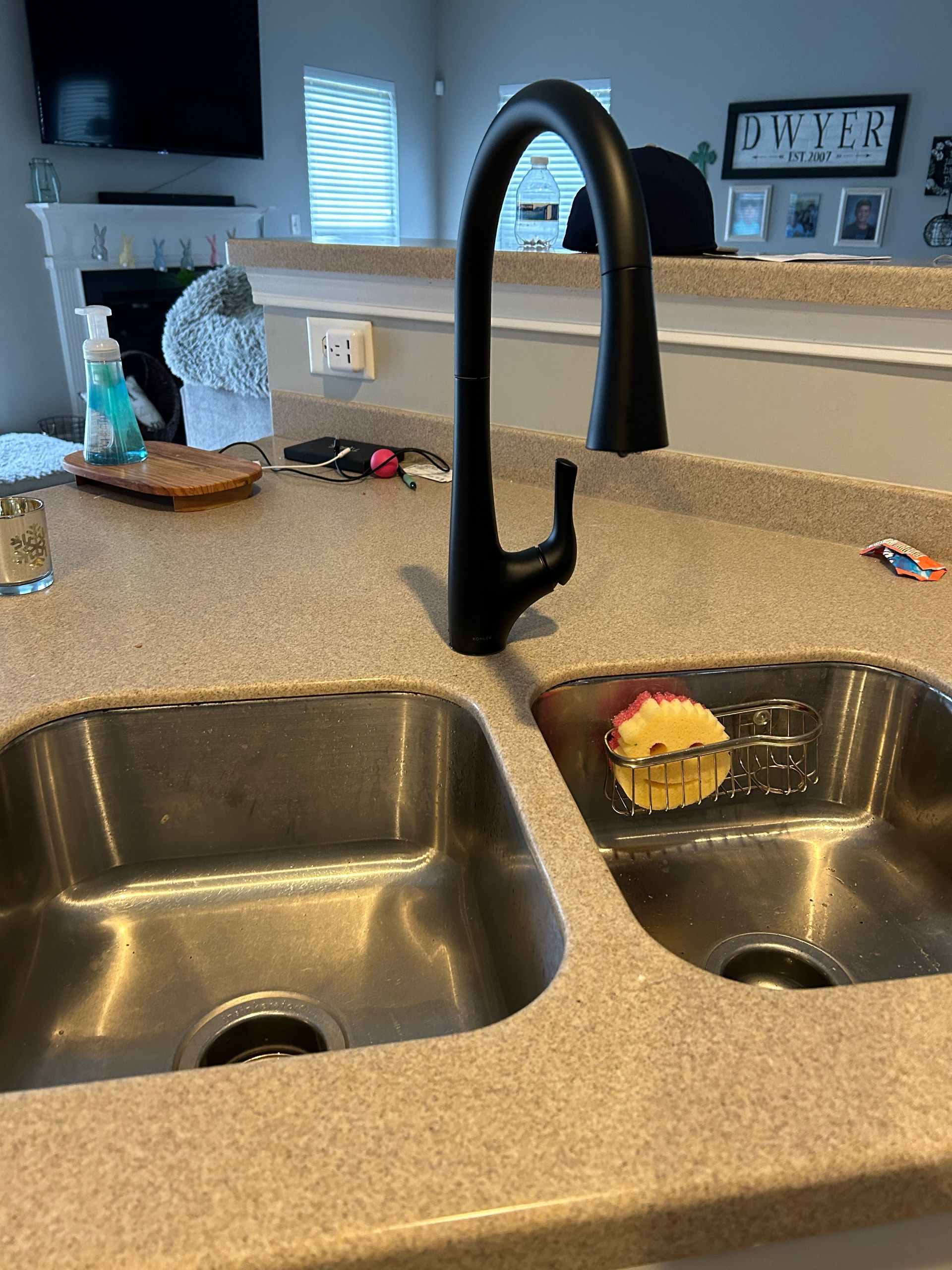 A kitchen sink with two stainless steel sinks and a black faucet.