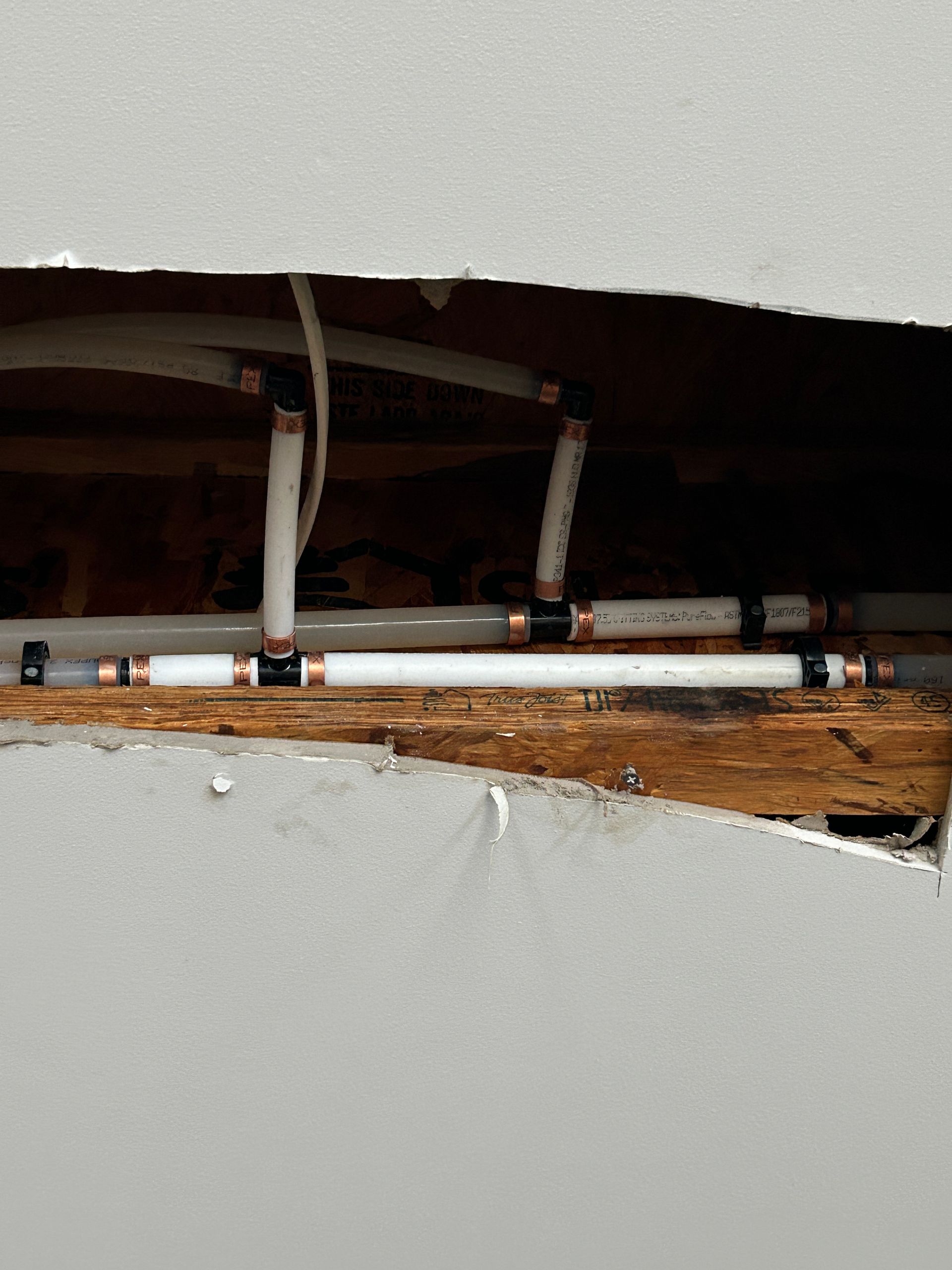 A hole in a wall with pipes coming out of it.