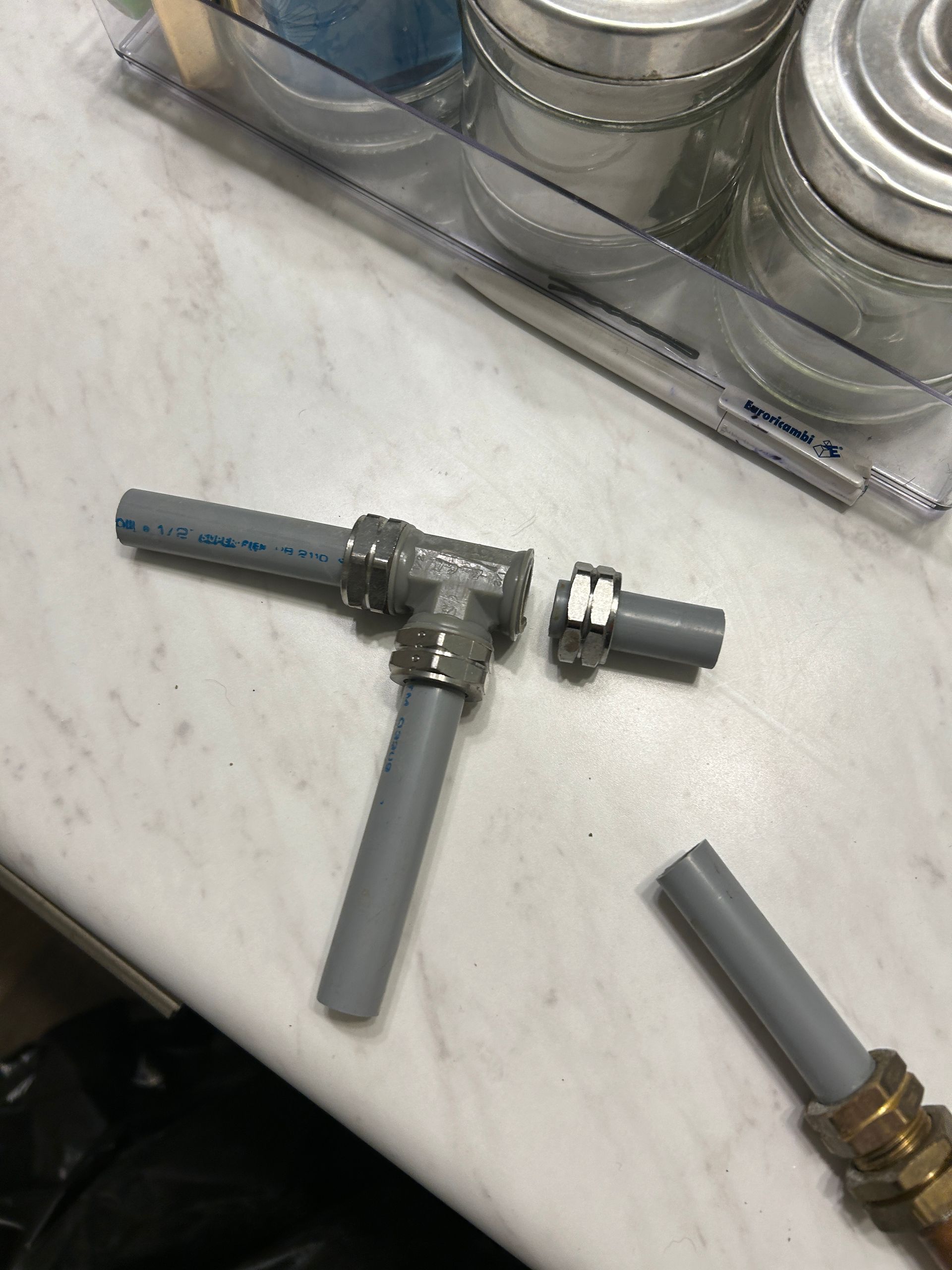 A broken pipe is sitting on a counter next to some jars