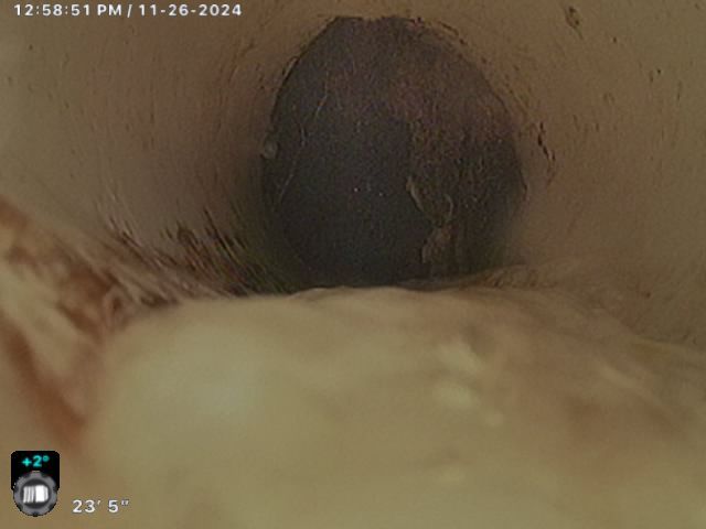 A close up of a pipe with a clock on the bottom of it.