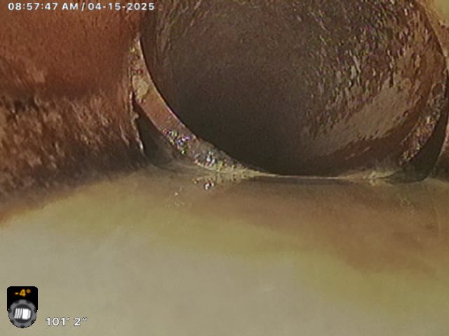 Sewer pipe interior with signs of rust and buildup.