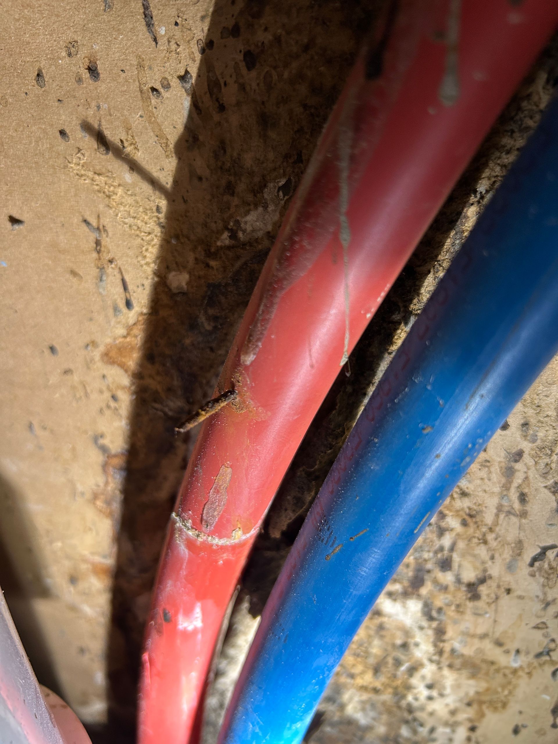 A close up of a red and blue pipe on a wall.