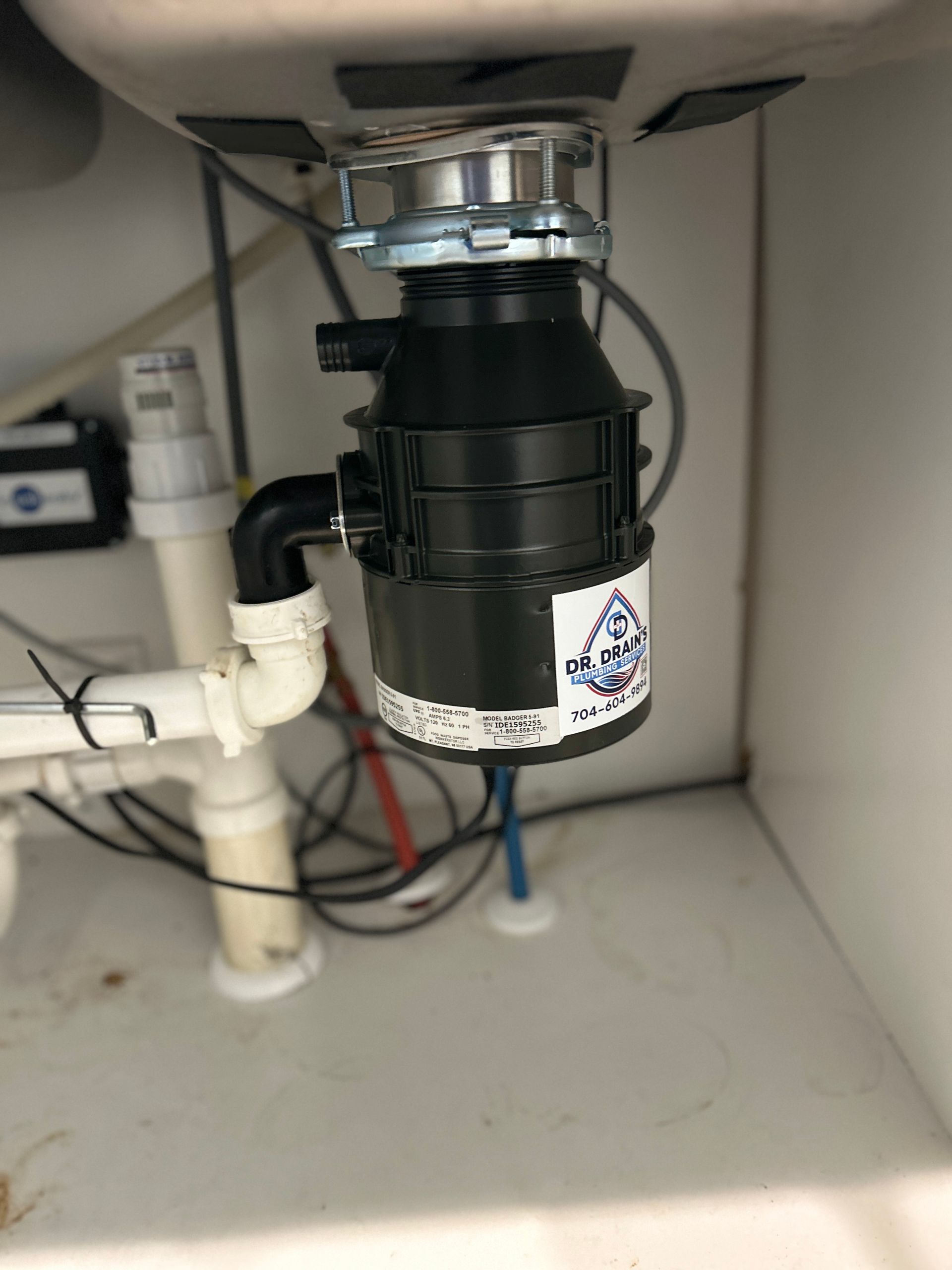 A garbage disposal is sitting under a sink in a kitchen.