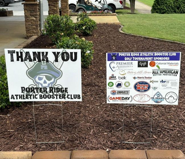 Two thank you signs are sitting on the side of a road.